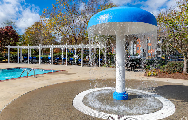 A blue and white water fountain in the middle of a pool area.