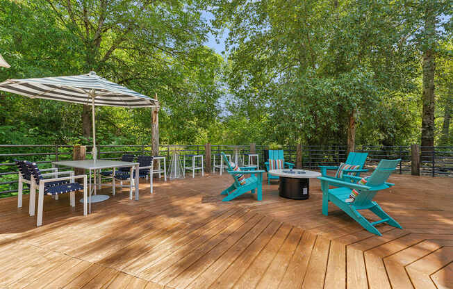 A wooden deck with blue chairs and a table.