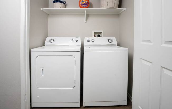 A white washing machine and dryer in a small laundry room.