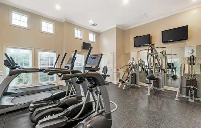 A gym with treadmills, exercise bikes, and other equipment.