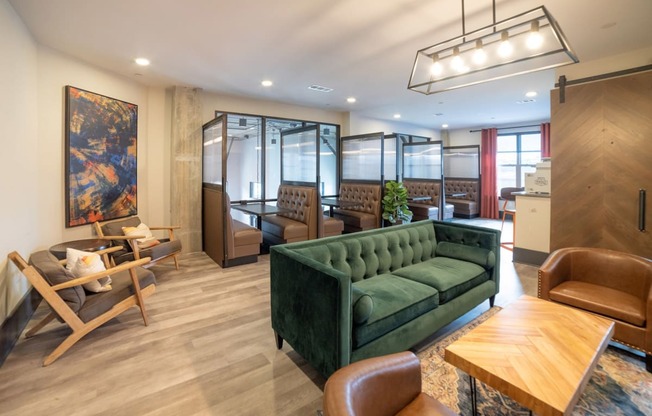a living room with a green couch and chairs