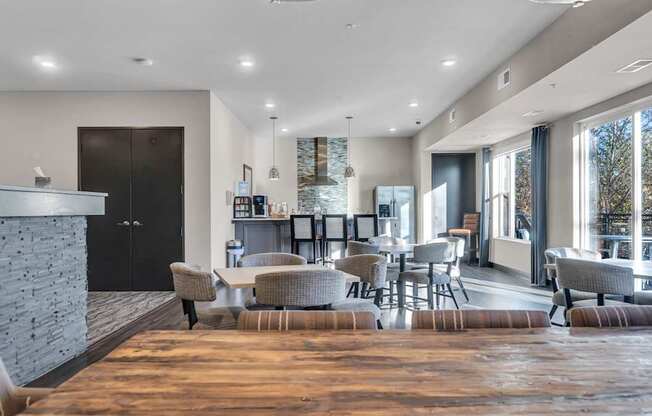 A modern living room with a stone fireplace and a large window.