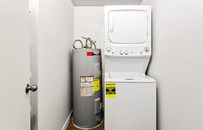 A water heater and a stove are in a small room.