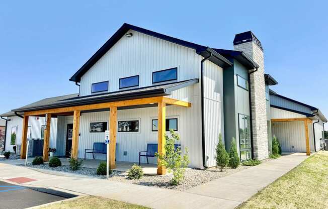A modern building with a combination of white and grey exterior and a black roof.