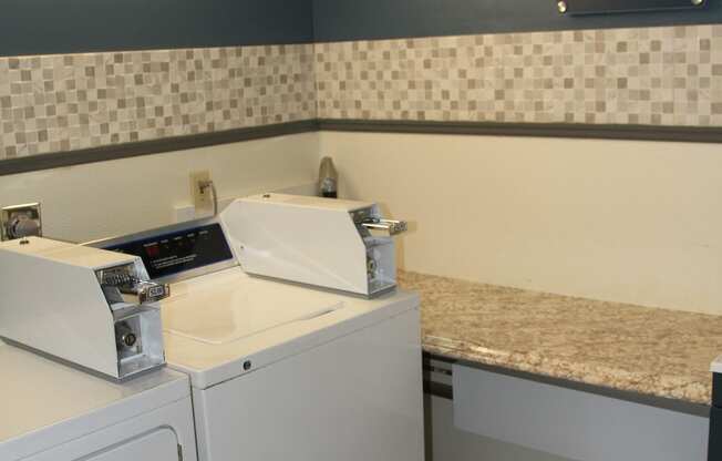 a laundry room with two washers and a counter with two washing machinesat Renew Worcester, Worcester, 01602