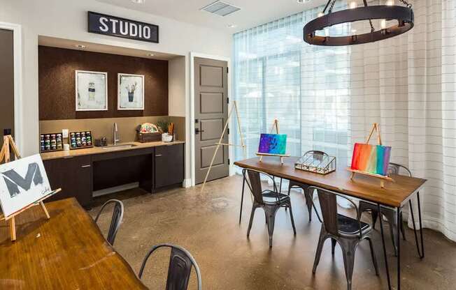 A room with a wooden table and chairs and a sign that says "STUDIO" on the wall.