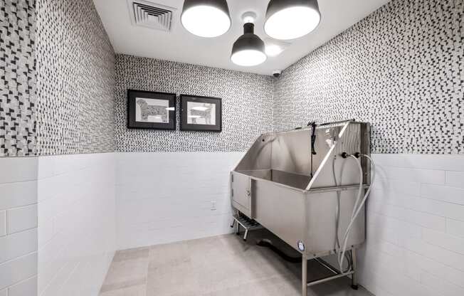 a stainless steel bath tub in a bathroom with white tiled walls and a wall