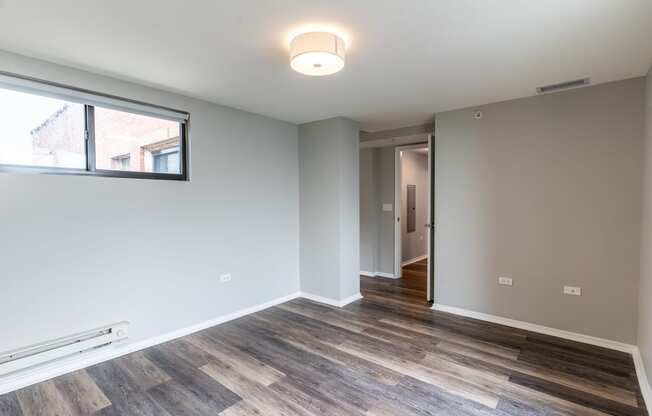 a living room with wood flooring and a large window