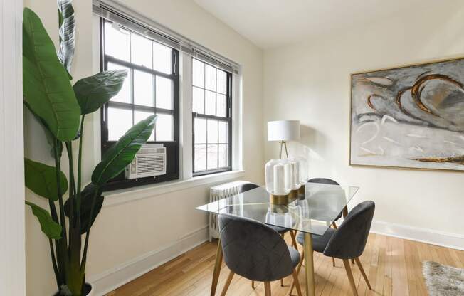 dining area with table chairs, houseplants, modern artwork and hardwood flooring at the dahlia apartments in washington dc