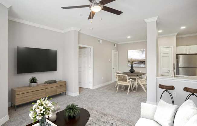 a living room with a ceiling fan and a tv  at The Verandah, Austin, TX