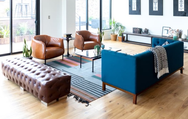 a living room with a blue couch and brown chairs