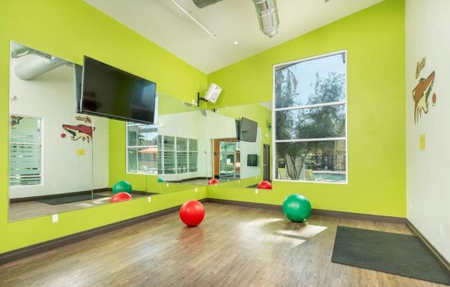 Fitness room with hardwood floors, large mirrors, and exercise equipment at Onnix Apartments