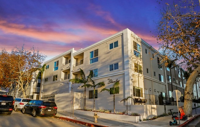 an apartment building on a city street with parked cars