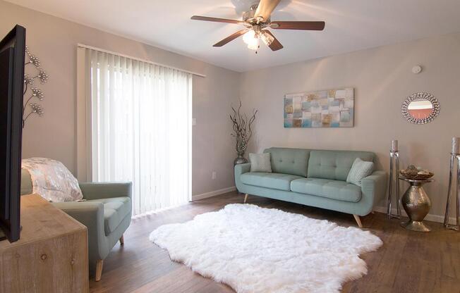 a living room with a bed and a flat screen tv