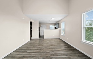 an empty living room and kitchen with wood flooring and a window at Diamond Ridge Townhomes, Oklahoma City, 73114