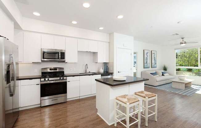 A modern kitchen with white cabinets and a black countertop.