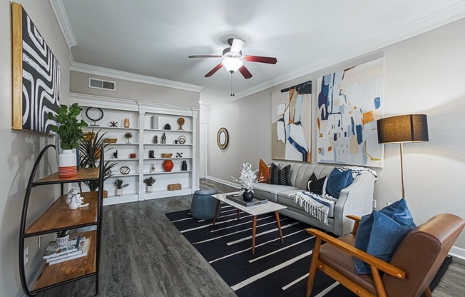 staged living room with hardwood-style flooring and ceiling fan