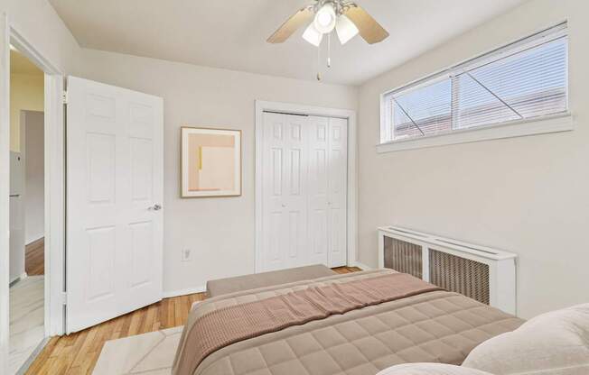 A bedroom with a large bed and a ceiling fan.