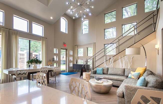 A living room with a staircase and a dining table.