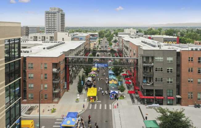 an aerial view of a city street with buildings and a bridge