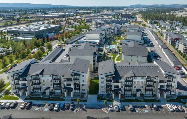 an aerial view of an apartment complex with cars parked in a parking lot