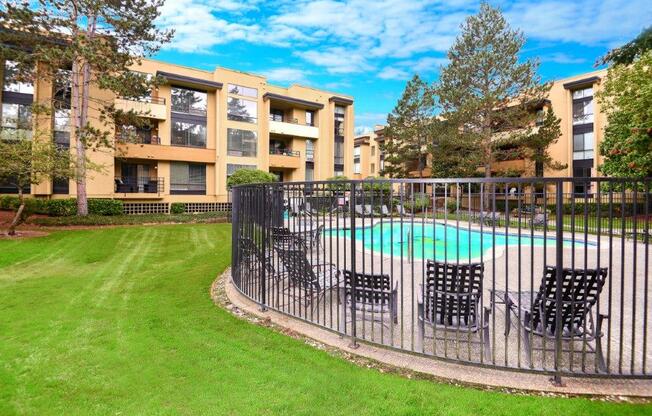 12 Central Square Pool with chairs, gates, and grass field