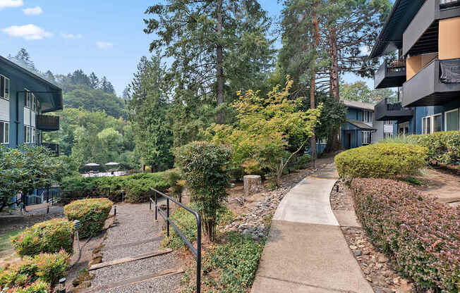 A pathway with a metal railing on the left side and a building on the right side.