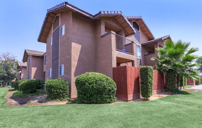 a house with a lawn in front of a brick building