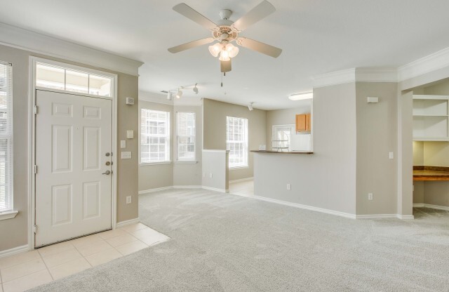 View of Unfurnished Living Room, Showing Built-In Shelves, Desk, and View of Kitchen at Cottonwood Ridgeview Apartments