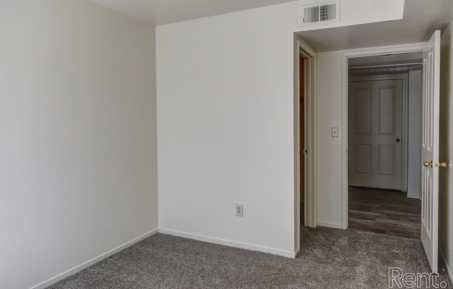 a bedroom with white walls and a carpeted floor