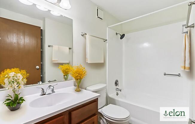 A bathroom with a white sink and a white toilet.