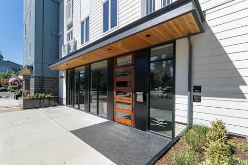 A modern building with a wooden entrance and glass doors.