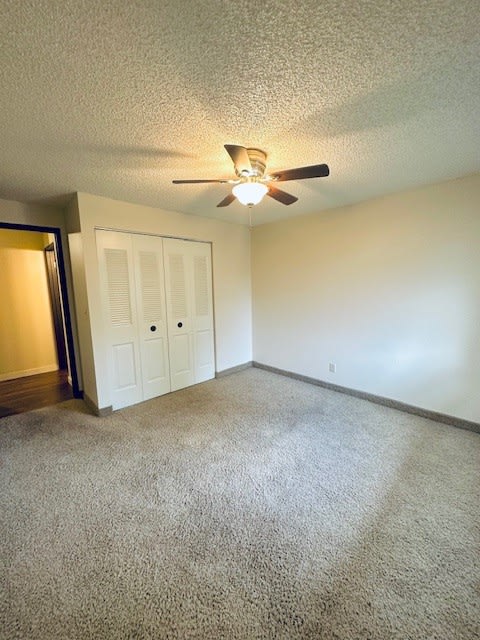 an empty living room with a ceiling fan