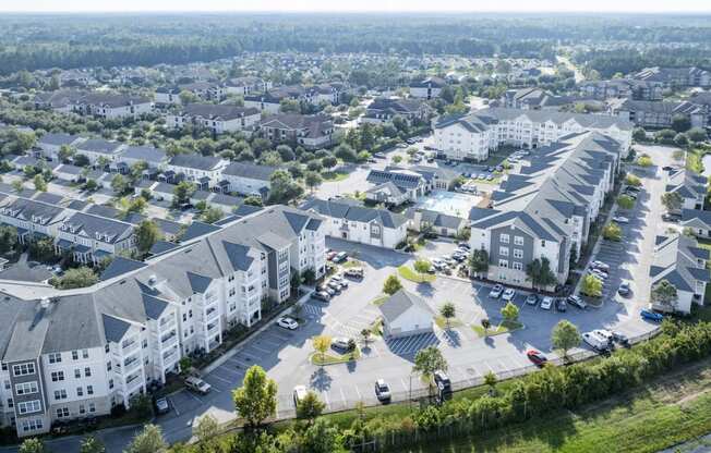 an aerial view of an apartment community with cars parked in a parking lot