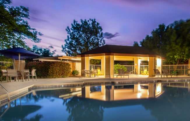 the pool and pavilion of a resort at night