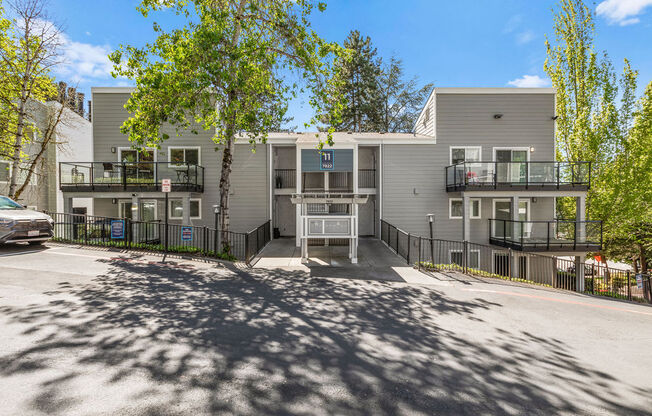an apartment building with a parking lot and trees
