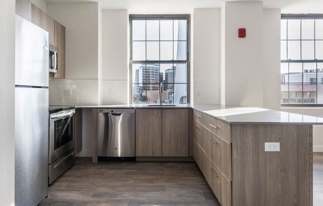 an empty kitchen with stainless steel appliances and a window