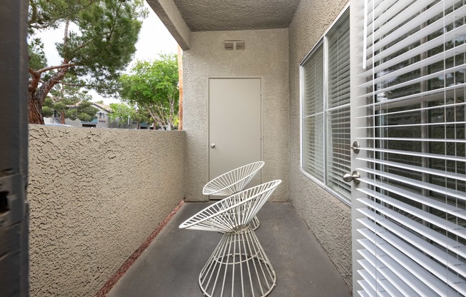 a patio with two chairs and a table in front of a door