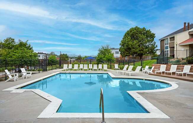 A large outdoor swimming pool surrounded by lounge chairs.