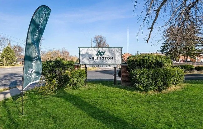 a sign in the grass with a tree in the background