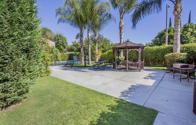 a park with a gazebo and benches and trees