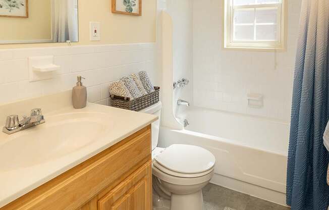 A bathroom with a toilet, sink, and bathtub.