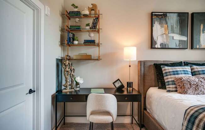 a bedroom with a bed and a desk with a chair