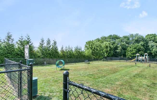 a park with a playground and a chain link fence