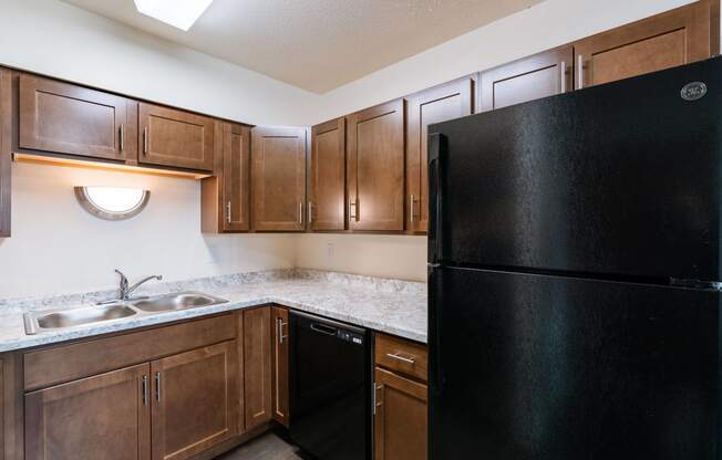 full kitchen with black refrigerator and sink at the reserve at walnut creek apartments. Moorhead, MN South Park Apartments