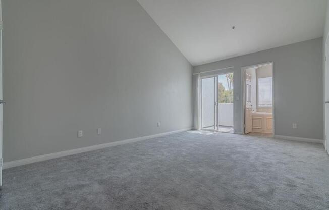 an empty living room with white walls and a door at Warner Center Townhomes, Canoga Park, CA 