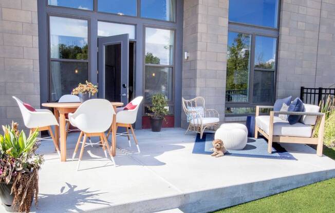 a patio with a table and chairs and a dog laying on the ground