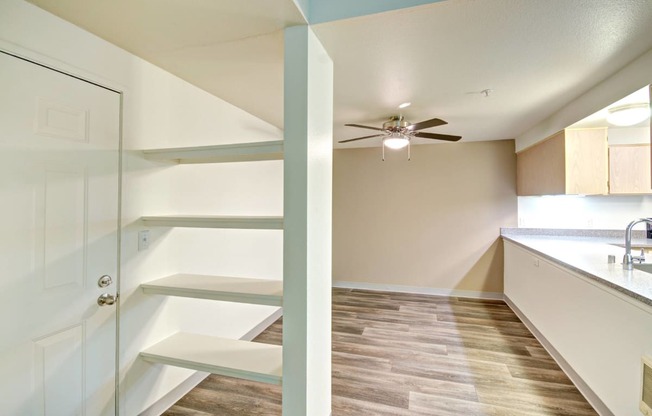 a kitchen with white cabinets and a ceiling fan