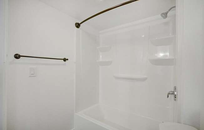 A white bathroom with a tub and toilet.