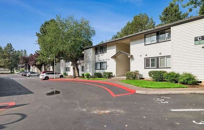 A parking lot in front of a building with a red line painted on the pavement.